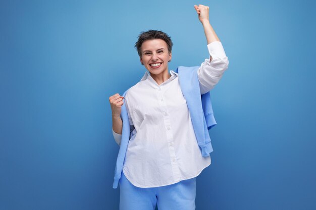 Alegre e alegre jovem morena com um corte de cabelo curto em uma camisa branca