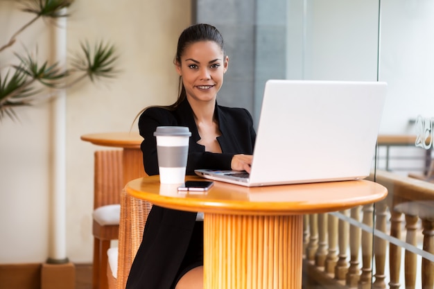 Alegre elegante empresaria con laptop