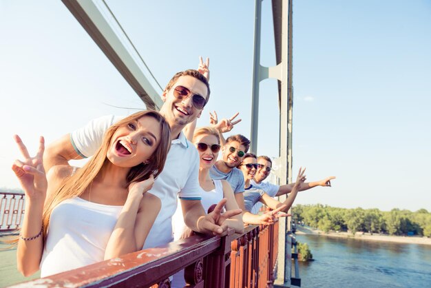 Foto alegre emocionado mejores amigos divirtiéndose y mostrando vsign con f