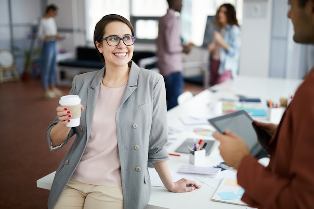 Alegre empresaria hablando con un colega en el descanso