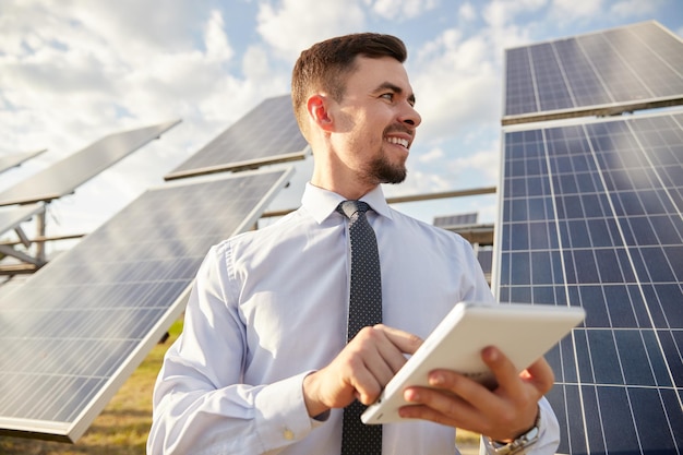 Foto alegre empresário masculino navegando tablet na fazenda solar