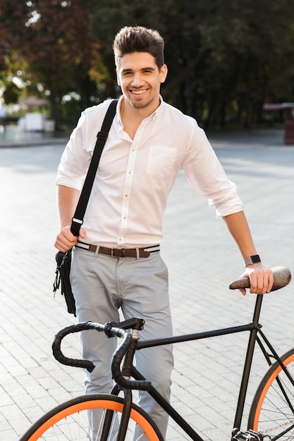 Alegre empresario vestido con camisa de pie