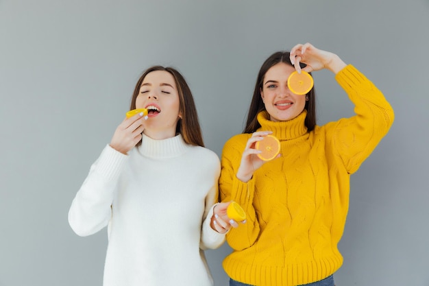 alegre engraçado cômico positivo nu natural meninas puras com dois pedaços de laranja