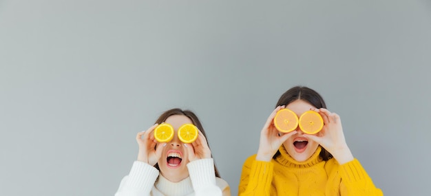 Alegre engraçado cômico positivo nu natural meninas puras com dois pedaços de laranja