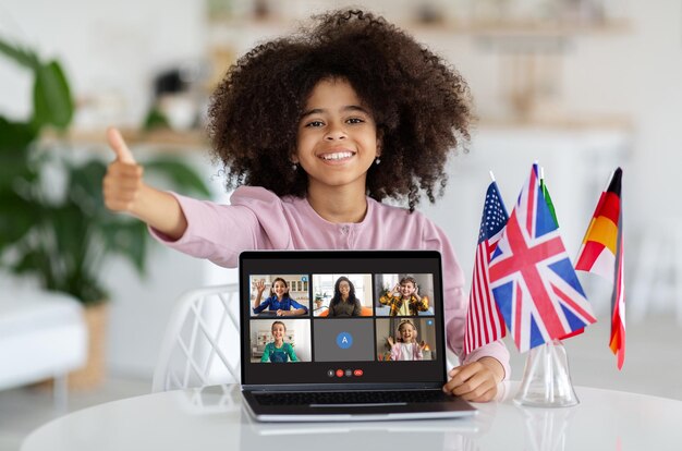 Alegre estudiante afroamericana haciendo una llamada de video con una computadora portátil