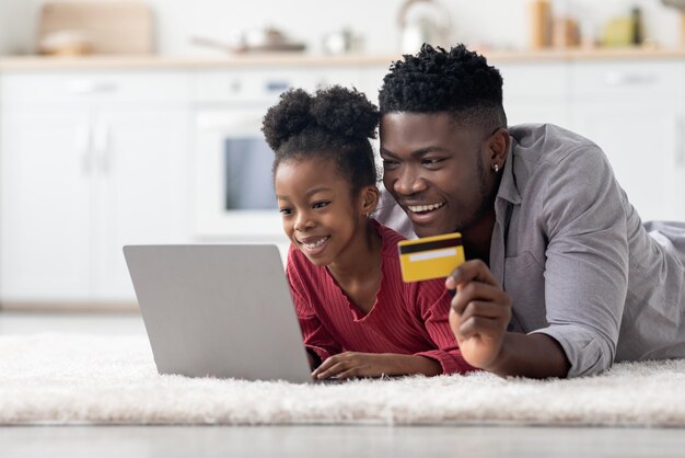 Alegre familia afroamericana comprando en línea juntos