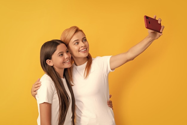 Alegre família de mãe mulher e criança fazendo selfie em smartphone selfie