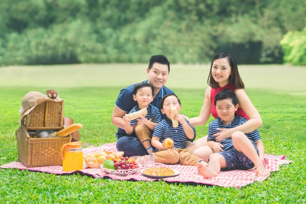 Alegre família fazendo piquenique juntos no parque