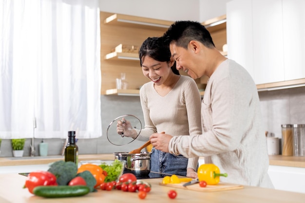 Alegre família japonesa gostando de cozinhar juntos em casa