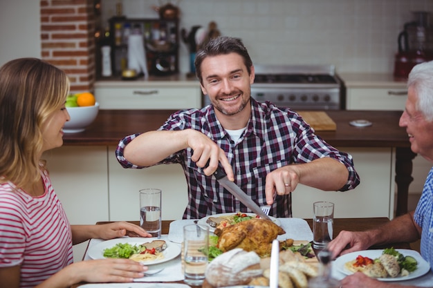 Alegre familia sentada en la mesa de comedor