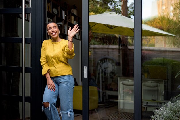 Alegre, feliz e satisfeita empresária ou empresário sorridente após uma reunião bem-sucedida Pessoa adulta na porta da casa cumprimentando parceiros de negócios ou colegas acenando com a mão