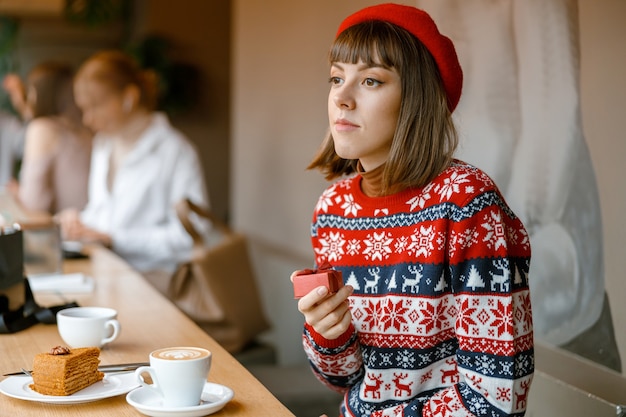 Alegre, feliz y hermosa dama caucásica descansa en una acogedora terraza de café