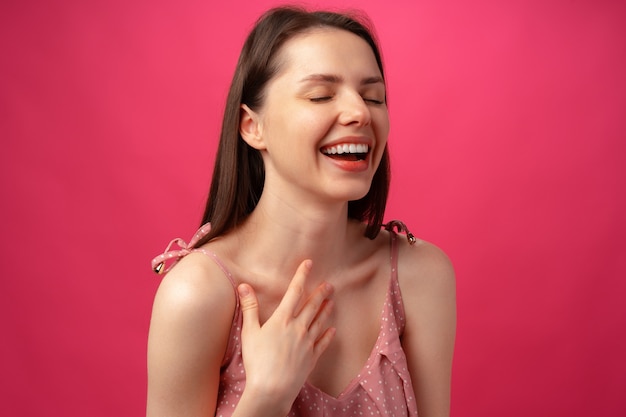 Alegre feliz jovem linda sorrindo e rindo contra um fundo rosa