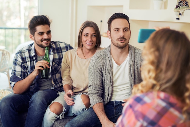 Alegre grupo de amigos divirtiéndose en casa, jugando a la asociación.