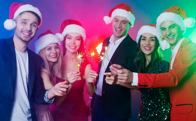 Foto alegre grupo de amigos con gorro de papá noel con champán