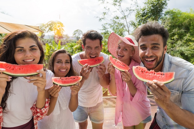 Alegre grupo de amigos con sandía rebanada sonrisa