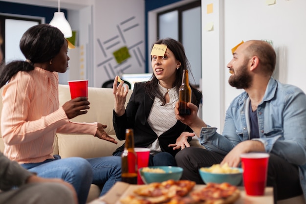 Alegre grupo de colegas disfrutando de un juego de charadas.