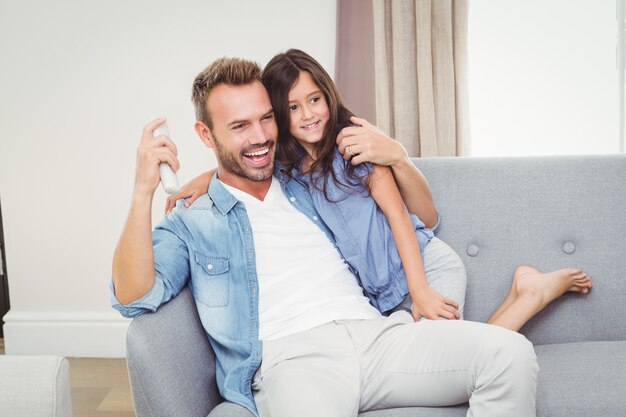 Alegre hija y padre viendo televisión