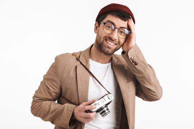 alegre, hombre, llevando, hipster, sombrero, regocijarse, mientras, sujetar y fotografiar, en, retro, frente, aislado, encima, pared blanca