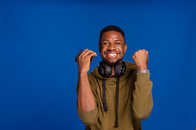 Alegre homem afro-americano usando aplicativo de telefone celular