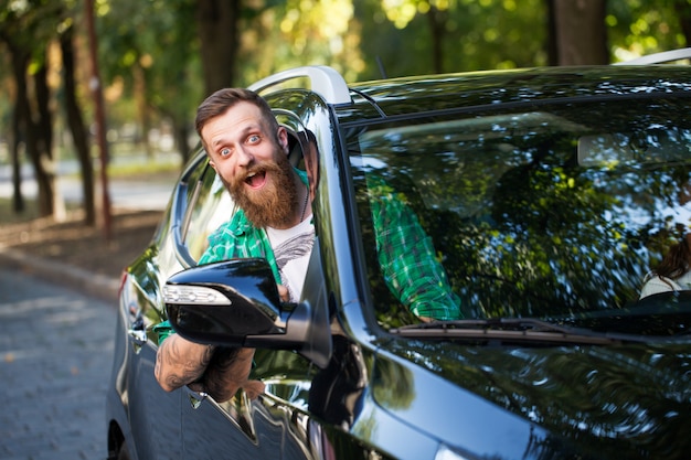 Alegre homem barbudo no carro.