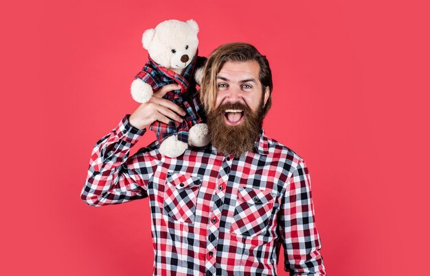 Alegre homem barbudo segurar ursinho de pelúcia macho se sentir brincalhão com urso brutal homem hipster maduro brincar com brinquedo feliz aniversário estar de bom humor feliz dia dos namorados vendas do dia dos namorados