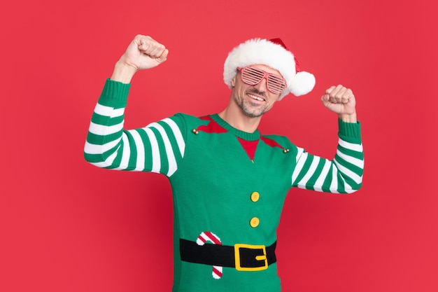 Alegre homem de sucesso em traje de elfo e óculos de festa cara de natal com chapéu de papai noel