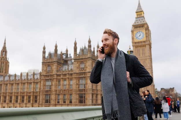 Alegre homem falando ao telefone no contexto do Big Ben de Londres