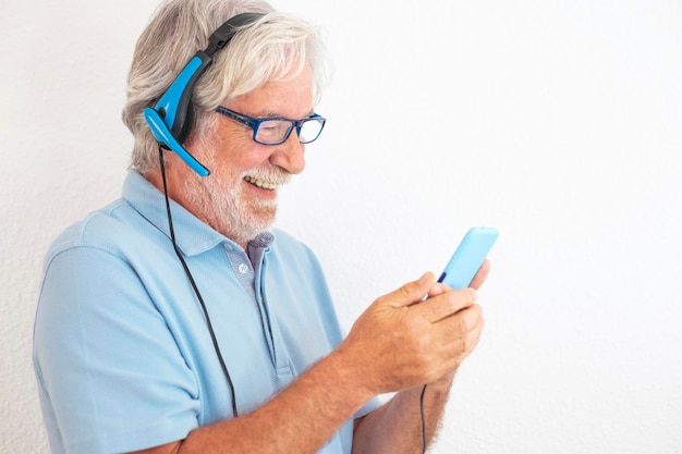 alegre homem sênior usando fones de ouvido com microfone usando telefone para videochamadas com amigos