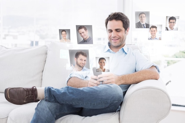 Alegre homem sentado no sofá usando seu smartphone contra fotos de perfil