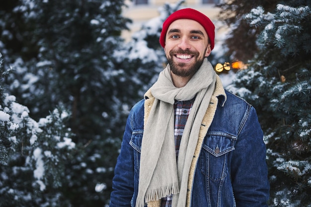 Alegre jovem caminhando na floresta de inverno