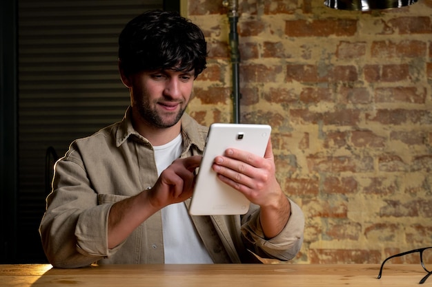 Alegre jovem gerente de cabelos pretos segurando um tablet digital Um empresário usando um aplicativo de negócios em um tablet
