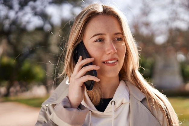 Alegre jovem mulher caucasiana falando no telefone