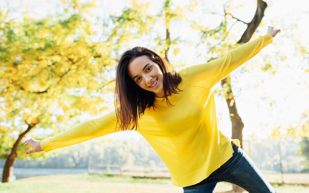 Alegre joven adolescente posando afuera en el parque natural Bastante joven hermosa estudiante femenina descansando al aire libre en el parque de la ciudad