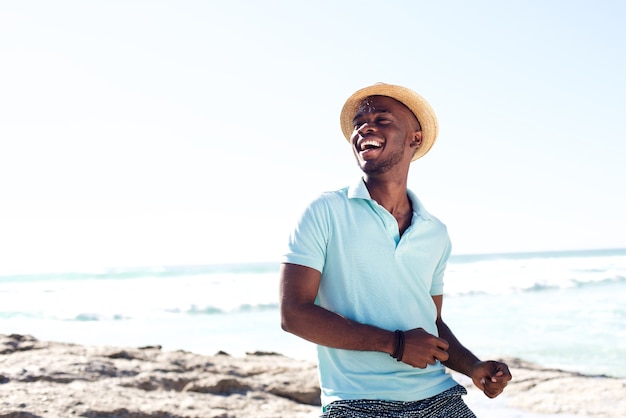 Alegre joven africano disfrutando en la playa