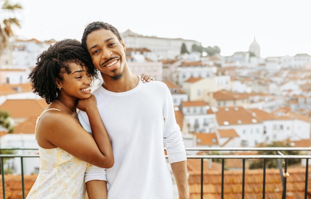 Alegre joven afroamericana mujer abrazando a un hombre en la ciudad disfrutar de la fecha y viajar al aire libre