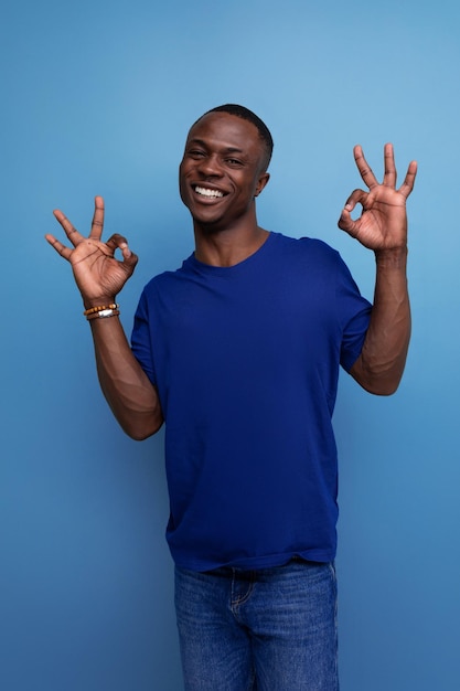 Alegre joven americano en camiseta azul gesticulando