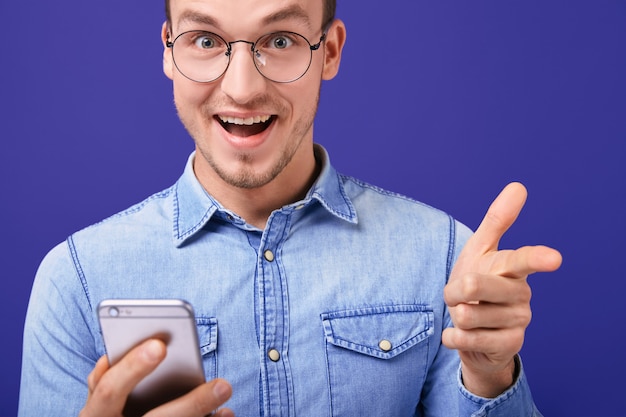 Alegre joven apuntando hacia delante con la mano alegremente