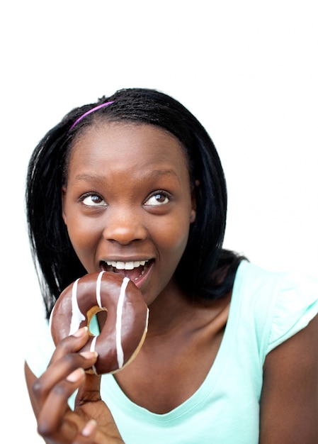 Alegre joven comiendo un donut de chocolate