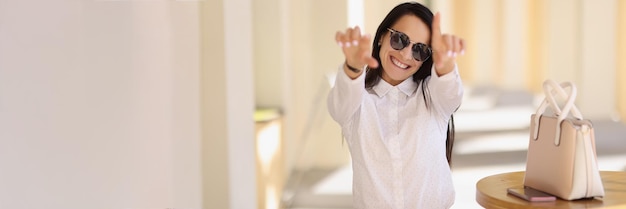 Alegre joven feliz en traje elegante muestra algunos símbolos con las manos