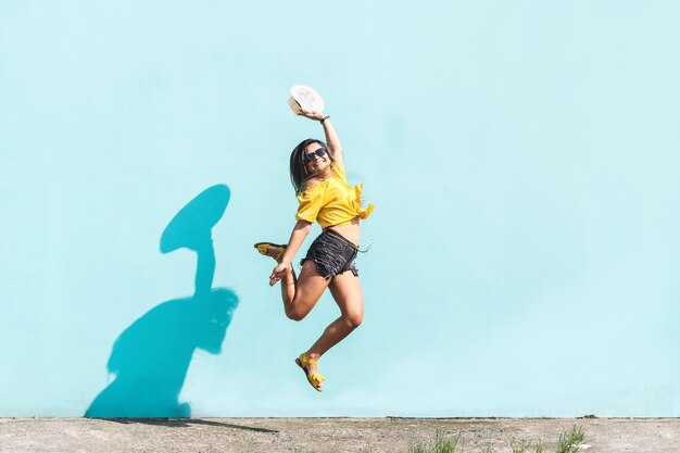 Alegre joven latinoamericana saltando de felicidad en el concepto urbano de la calle