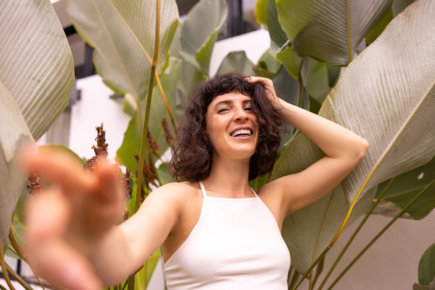 Alegre joven morena caucásica en la parte superior sonriendo con los dientes a la cámara al aire libre Concepto de estilo de vida de humor