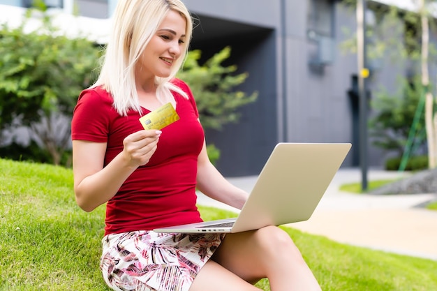 alegre joven navegando por internet en su laptop al aire libre en el parque