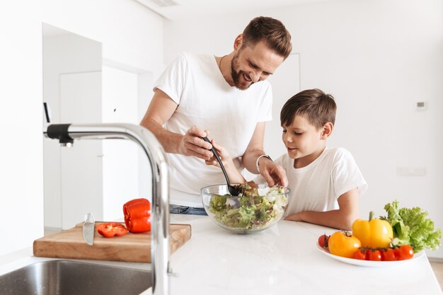 Alegre joven padre papá cocinando con su hijo