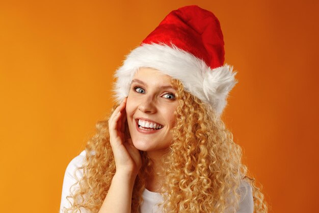 Alegre joven rubia rizada vistiendo gorro de Papá Noel