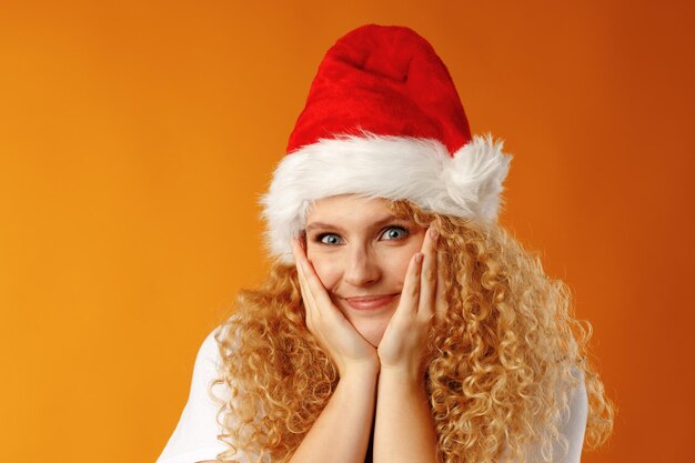 Alegre joven rubia rizada vistiendo gorro de Papá Noel