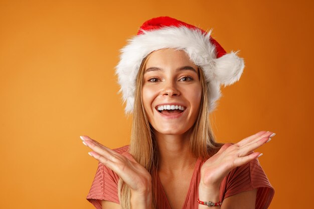 Alegre joven rubia vistiendo gorro de Papá Noel