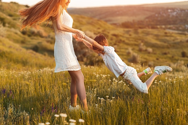 Alegre jovencita pelirroja divirtiéndose con feliz hermano pequeño