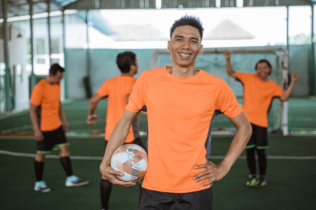 Alegre jugador de fútbol sala masculino posa de pie con los pulgares hacia arriba