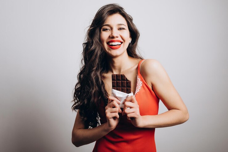 Alegre linda chica morena ha tomado un bocado de chocolate